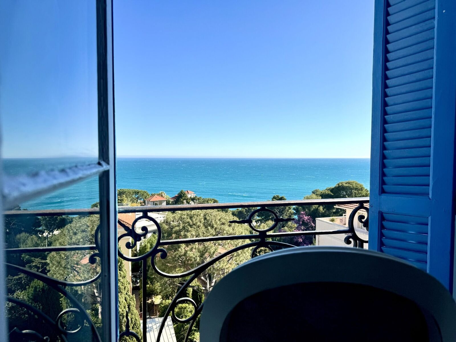 Persiane azzurre aperte su un balcone sopra il Mediterraneo all'Hotel Normandy, Cap-d'Ail